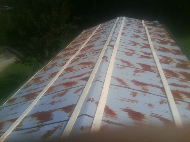 Rusted metal roof panels with new wood purlins before replacement — Storm Damage Roof Repair in Aubrey by Roofing Brothers
