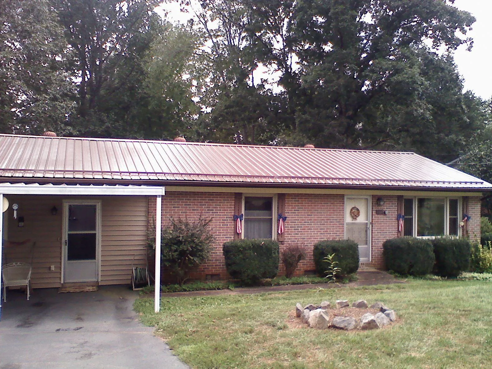 Bronze metal roof and carport on a brick ranch home — Roof Repair work by our crew in Aubrey
